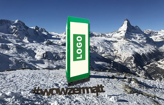 grünweisse aufblasbare Werbesäule auf attraktivem Promotionsplatz beim Matterhorn