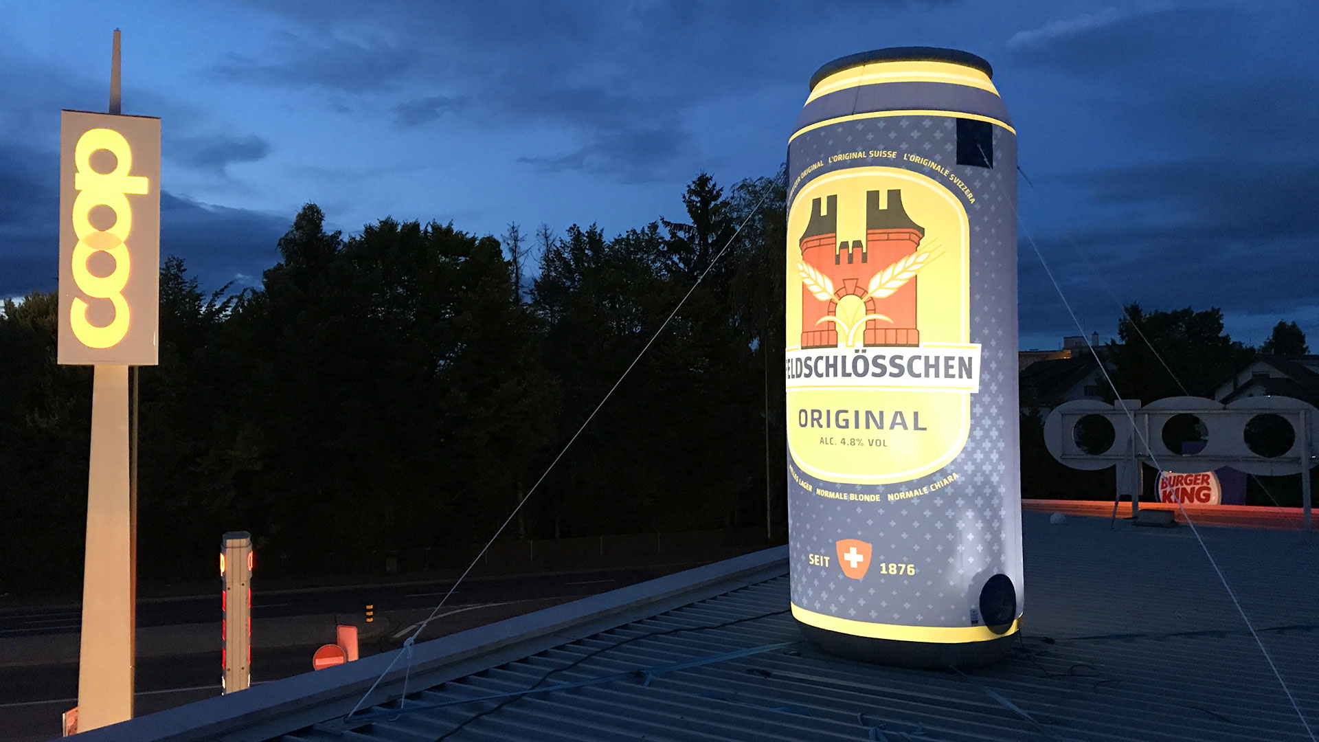aufblasbare-werbetraeger-Bierdose-Feldschloesschen-1920 aufblasbare beleuchtete Bierdose von Feldschlösschen steht auf dem Dach von COOP und erweckt die Aufmerksamkeit auf sich