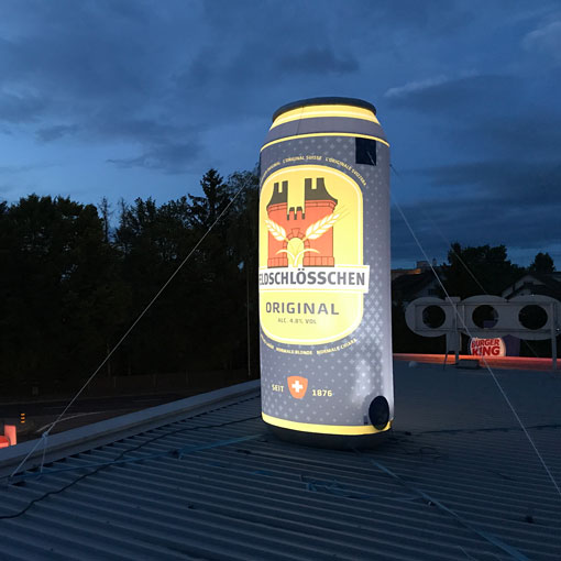 aufblasbare-werbetraeger-Bierdose-Feldschloesschen-510 aufblasbarer Quaderwürfel steht in einer Gartenanlage und weist auf die Möglichkeit der Kulturerlebnisse am Zürichsee hin